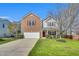 Charming two-story home featuring a brick facade, red shutters, a well-maintained lawn, and a two car garage at 6817 Osprey Landing Dr, Wendell, NC 27591