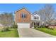 Exterior shot of a home, highlighting the red shutters, brick, and vinyl siding in a lush green setting at 6817 Osprey Landing Dr, Wendell, NC 27591