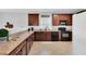 Well-lit kitchen featuring dark wood cabinets, modern appliances, neutral countertops, and an undermount sink at 6817 Osprey Landing Dr, Wendell, NC 27591