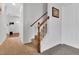 Hallway and staircase with neutral carpet and white trim, offering an inviting entry to the home at 6817 Osprey Landing Dr, Wendell, NC 27591