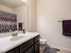 Neat bathroom featuring a white sink, dark wood cabinet, decorative mirror, and shower with curtain at 700 Treviso Ln, Apex, NC 27502
