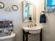 Charming powder room with a unique sink, beach themed decor, and a decorative mirror at 700 Treviso Ln, Apex, NC 27502