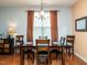 Well-lit dining room with wooden table set and chairs, complemented by decorative curtains at 700 Treviso Ln, Apex, NC 27502