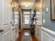 Hallway view with hardwood floors, white trim, and decorative mirrors at 700 Treviso Ln, Apex, NC 27502