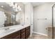 Bright bathroom featuring double sink vanity, large mirror, and glass shower at 78 Radcliffe Ct, Clayton, NC 27527