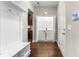 Hallway with hardwood floors, storage and hooks, and a view of the kitchen and open laundry closet with appliances at 78 Radcliffe Ct, Clayton, NC 27527