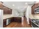 Spacious kitchen featuring rich wood cabinets, granite countertops, stainless steel appliances, and open access to the living area at 78 Radcliffe Ct, Clayton, NC 27527