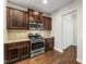A modern kitchen with stainless steel appliances, granite countertops, and dark wood cabinets at 78 Radcliffe Ct, Clayton, NC 27527