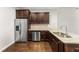 Well-appointed kitchen with stainless steel appliances, granite countertops, dark cabinets, and hardwood flooring at 78 Radcliffe Ct, Clayton, NC 27527