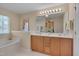 Bright bathroom featuring double vanity sinks, soaking tub, and natural light at 7920 Leonardo Dr, Durham, NC 27713