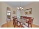 Cozy dining room featuring hardwood floors, a stylish chandelier, and ample natural light at 7920 Leonardo Dr, Durham, NC 27713
