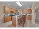 Open kitchen featuring wooden cabinets, stainless steel appliances, breakfast bar and tile flooring at 7920 Leonardo Dr, Durham, NC 27713