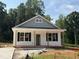 Charming single-story home featuring a welcoming front porch, black shutters, and durable vinyl siding at 87 Legolas Ct, Middlesex, NC 27557