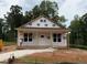 New construction home showcasing a covered porch and a simple facade in a natural wooded setting at 87 Legolas Ct, Middlesex, NC 27557