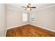 Bright bedroom features hardwood floors, a ceiling fan, and natural light from two windows at 913 Clayton Rd, Angier, NC 27501