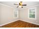 Bedroom featuring two windows, hardwood floors, base molding, and a ceiling fan at 913 Clayton Rd, Angier, NC 27501