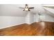 Large, finished bonus room features a ceiling fan, built-in shelves, and hardwood floors at 913 Clayton Rd, Angier, NC 27501
