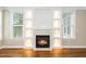 Fireplace featuring built-in shelving and decorative lighting; hardwood floors and bright natural light at 913 Clayton Rd, Angier, NC 27501