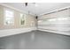 Spacious garage with tall ceilings, bright windows, a door to the backyard, and sealed concrete floors at 913 Clayton Rd, Angier, NC 27501