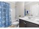 Well-lit bathroom with a shower-tub combo, tile floors and a dark vanity at 966 Shoofly Path, Apex, NC 27502