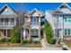 Charming two-story townhome featuring a covered front porch with stone accents and a balcony at 966 Shoofly Path, Apex, NC 27502