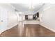 Well-lit living room featuring hardwood floors, a chandelier, and a view into the kitchen at 966 Shoofly Path, Apex, NC 27502