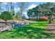 Expansive backyard featuring lush green lawn, stone retaining wall, and mature trees at 100 Pebble Ridge Farms Ct, Cary, NC 27513