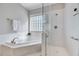Bright bathroom showcasing a shower and soaking tub with modern fixtures and glass block window at 100 Pebble Ridge Farms Ct, Cary, NC 27513