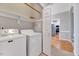 Practical laundry room with modern washer and dryer, shelving, and adjacent kitchen access at 100 Pebble Ridge Farms Ct, Cary, NC 27513