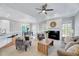 Bright living room featuring a fireplace, elegant ceiling fan, and comfortable seating arrangement at 100 Pebble Ridge Farms Ct, Cary, NC 27513