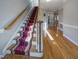 Hallway with wood flooring, carpeted stairs, and neutral walls, creating an inviting transitional space at 101 Sundance Pl, Chapel Hill, NC 27514