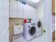 Convenient laundry room features cabinetry, a sink, and white appliances at 101 Sundance Pl, Chapel Hill, NC 27514