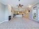 Open-concept living room boasts a fireplace, ceiling fan, and adjacent kitchen area, perfect for entertaining at 101 Sundance Pl, Chapel Hill, NC 27514