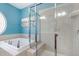 Close up of bathroom featuring a walk-in shower, soaking tub, and tiled walls at 10411 Rosegate Ct # 202, Raleigh, NC 27617