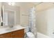 Bathroom with a single sink vanity, toilet, shower and tub combo with light blue shower curtain at 10411 Rosegate Ct # 202, Raleigh, NC 27617