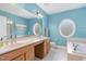 Bright bathroom featuring double sinks, a large mirror, and a separate tub and shower at 10411 Rosegate Ct # 202, Raleigh, NC 27617