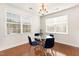 Dining area with hardwood floors, a glass table, four blue chairs, natural light and light fixture at 10411 Rosegate Ct # 202, Raleigh, NC 27617