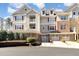 Three-story home featuring garages, multiple windows, dormers, neutral colors, and a balcony on a sunny day at 10411 Rosegate Ct # 202, Raleigh, NC 27617