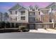 Exterior shot of condos featuring multi-level garages, multiple windows, and lush landscaping at 10411 Rosegate Ct # 202, Raleigh, NC 27617