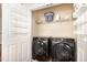 Modern laundry room with front load washer/dryer and wire shelving at 10411 Rosegate Ct # 202, Raleigh, NC 27617