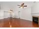 Spacious living room with hardwood floors, neutral walls, fireplace, and ceiling fans with doors leading to other rooms at 10411 Rosegate Ct # 202, Raleigh, NC 27617