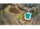 Aerial view of community amenities including a pool, playground, and nature area with a pond, near homes and a walking path at 105 Della St, Chapel Hill, NC 27516