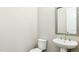 A quaint powder room features a pedestal sink, toilet, and a large mirror, offering a refreshing space at 105 Della St, Chapel Hill, NC 27516