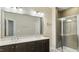 Bathroom featuring double vanity sinks, a large mirror, and a modern glass-enclosed shower at 105 Della St, Chapel Hill, NC 27516
