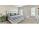 Comfortable bedroom with neutral tones, soft bedding, and abundant natural light through large windows at 105 Della St, Chapel Hill, NC 27516