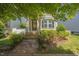 Inviting front exterior featuring a stone pathway leading to the entrance, surrounded by lush greenery and well-maintained landscaping at 105 Della St, Chapel Hill, NC 27516