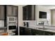 Gourmet kitchen featuring stainless steel appliances, granite countertops, and stylish dark cabinetry at 105 Della St, Chapel Hill, NC 27516