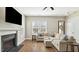 Comfortable living room with hardwood floors, a fireplace, and a cozy sectional sofa, perfect for relaxation and entertaining at 105 Della St, Chapel Hill, NC 27516