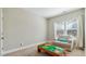 A bright playroom features a comfortable sofa, a table, and a window with blinds and curtains at 105 Della St, Chapel Hill, NC 27516