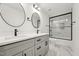 Modern bathroom with a double vanity, matte black hardware, and bright marble flooring with a glass enclosed shower at 109 Mohawk Dr, Louisburg, NC 27549